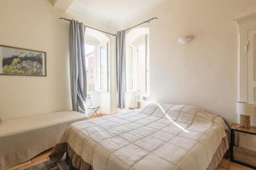 a bedroom with a bed and a window at Le Napoléon - Appt à moins dun km de la plage in LʼÎle-Rousse