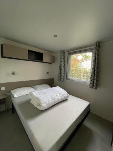 une chambre avec deux lits et une fenêtre dans l'établissement Superb Mobilhome Ba302 - 3 bedrooms Siblu Bonne Anse La Palmyre, aux Mathes