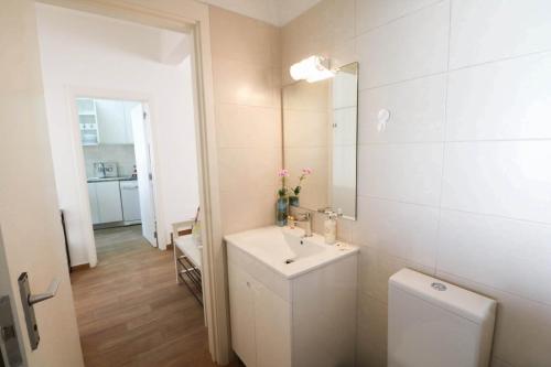 a white bathroom with a sink and a toilet at Casa Moura Golfe in Vilamoura