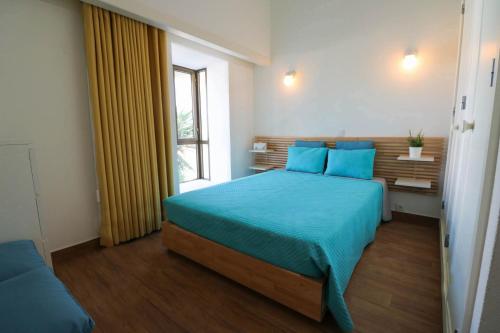 ヴィラモウラにあるCasa Moura Golfeのベッドルーム(青いベッド1台、窓付)