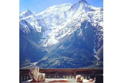 a woman sitting in front of a mountain view at Chalet Serena - luxury 7 Bedroom Chalet, Pool & Spa in Les Houches