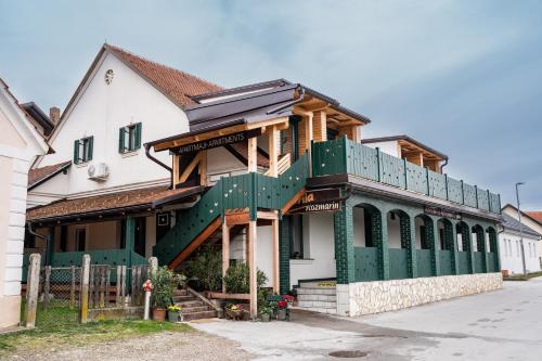 een huis met een groen en wit gebouw bij Apartmaji Babi in Markovci
