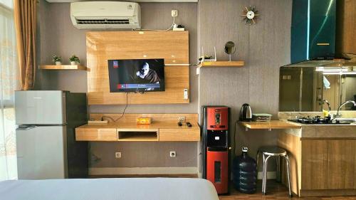 a kitchen with a refrigerator and a tv on the wall at Studio17 Elpis Kemayoran JIEXPO Sunrise View -Min Stay 3 nights- in Jakarta