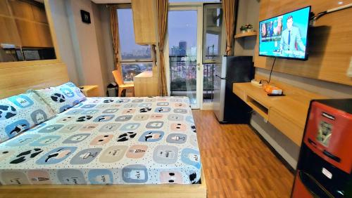 Schlafzimmer mit einem Bett und einem Flachbild-TV in der Unterkunft Studio Apartment JiExpo Kemayoran Sunrise View -Min Stay 3 nights- in Jakarta