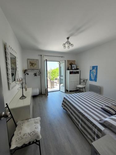une chambre avec un lit et une porte coulissante en verre dans l'établissement Maison pieds dans l eau St Florent, à Saint-Florent
