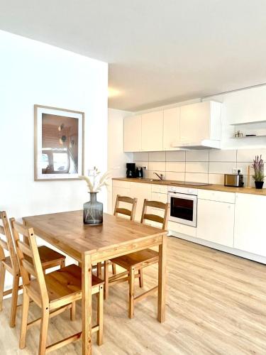 a kitchen with a wooden table and chairs at Modernes, vollmöbliertes Apartment in ruhiger Lage in Hemer