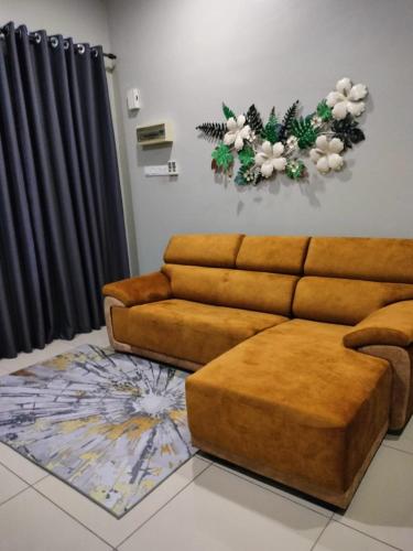 salon z kanapą i kwiatami na ścianie w obiekcie AR RAYYAN Homestay Banting w mieście Banting