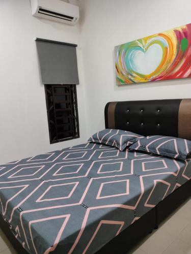 um quarto com uma cama e um quadro na parede em AR RAYYAN Homestay Banting em Banting