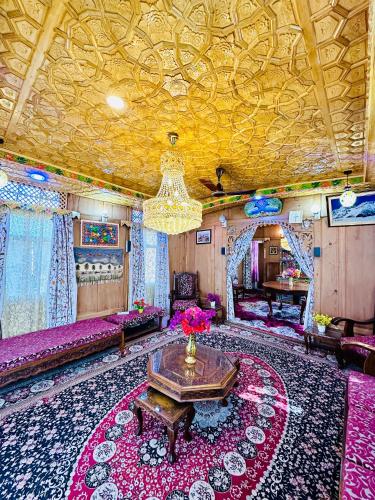 a living room with a table and a chandelier at Houseboat New world in Srinagar