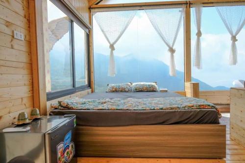 een bed in een kamer met een groot raam bij mimosa villa tam dao in Tam Ðảo