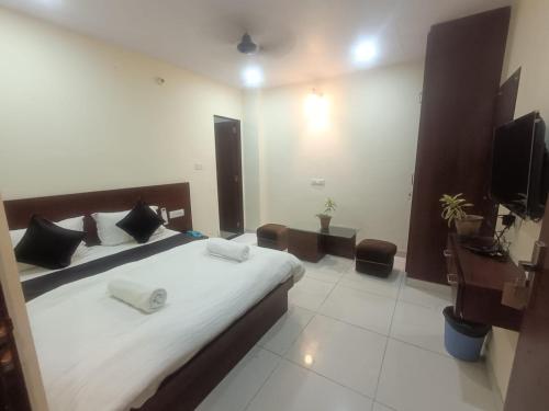 a bedroom with a large bed and a television at Hotel Shree Narayan Palace in Jaipur