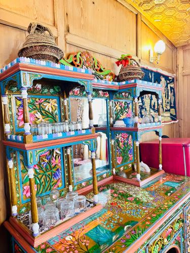 a colorful exhibit in a room with a table at Houseboat New world in Srinagar