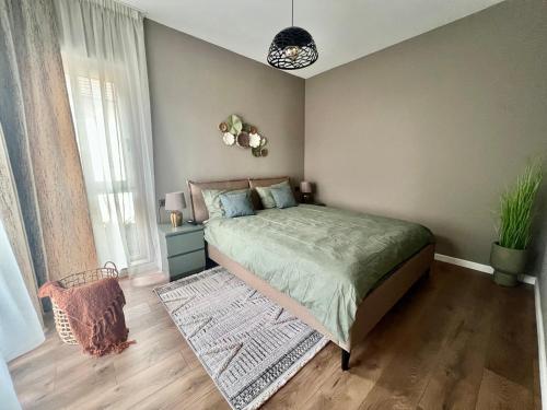 a bedroom with a bed with a green comforter at Rhodium Apartment in Cluj-Napoca