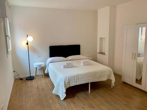 een witte slaapkamer met een bed en een lamp bij appartamento con cortile in Venetië