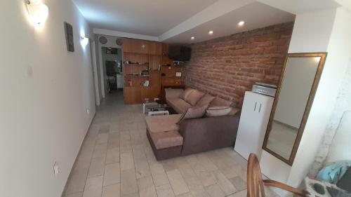 a living room with a couch and a brick wall at Apartments Perazica Do in Sveti Stefan