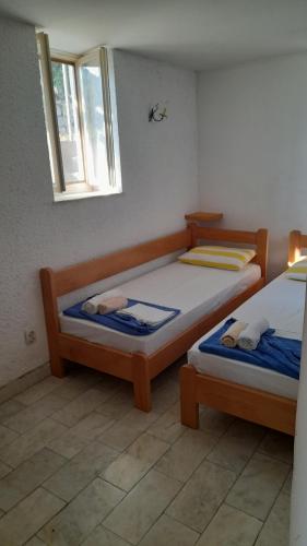 a bedroom with two beds and a window at Apartments Perazica Do in Sveti Stefan