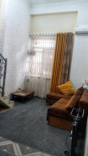 a living room with a couch and a table at Двухуровневая квартира студия - Duplex studio apartment in Dushanbe