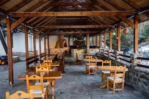 restauracja z drewnianymi stołami i drewnianymi krzesłami w obiekcie Pensiunea Casa Motului w mieście Arieşeni