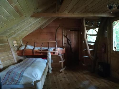 a bedroom in a tiny house with a bed at Les hébergements insolites de Quénécan in Perret