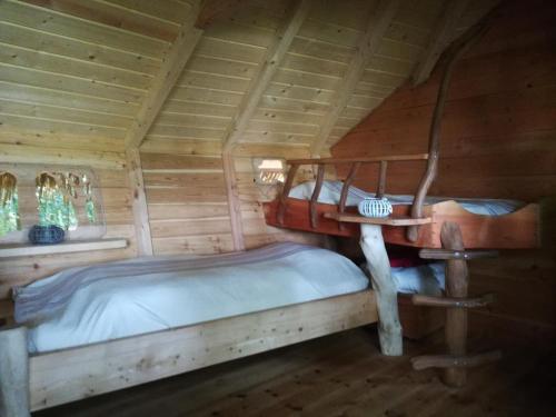 a bedroom with two beds in a log cabin at Les hébergements insolites de Quénécan in Perret