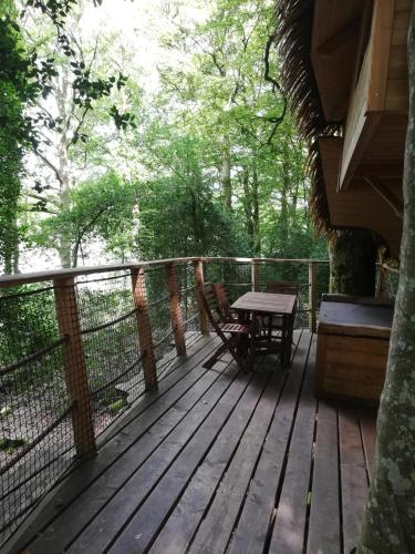 a wooden deck with a picnic table on it at Les hébergements insolites de Quénécan in Perret