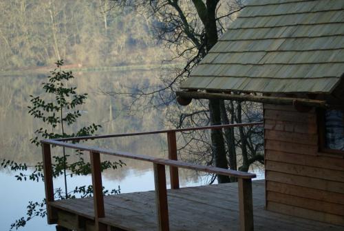 a porch of a house with a view of a lake at Les hébergements insolites de Quénécan in Perret