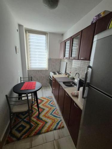 a small kitchen with a table and a refrigerator at City apartment in Prizren in Prizren