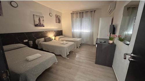 a hotel room with two beds and a television at Pensión Barlovento in Málaga