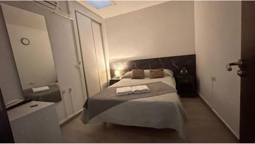 a bedroom with a bed with two towels on it at Pensión Barlovento in Málaga