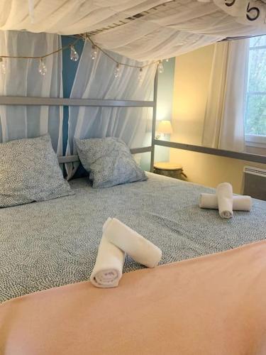 une chambre avec un lit avec deux serviettes dessus dans l'établissement Hélice - Maison sous les pins, à Longeville-sur-Mer