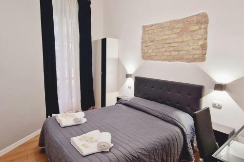 een slaapkamer met een bed met twee handdoeken erop bij Oasi Guest House in Rome
