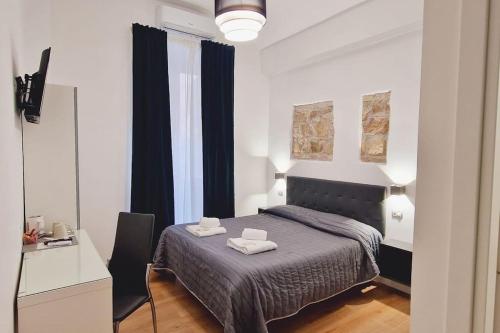 een slaapkamer met een bed met twee handdoeken erop bij Oasi Guest House in Rome
