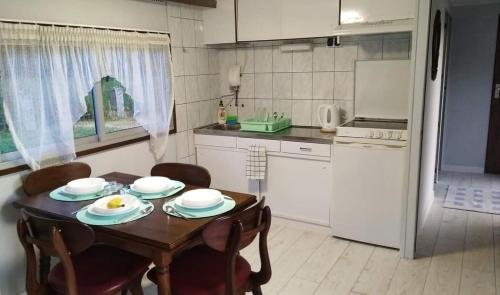 een keuken met een tafel en stoelen en een keuken met een koelkast bij Mogielicki Zakątek in Jurków