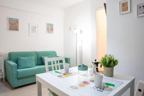 a living room with a table and a green couch at La casetta di Ella in Pisa