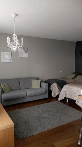 a living room with a couch and a chandelier at City Apartment Kauppakatu with Sauna in Iisalmi