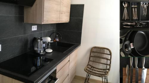a kitchen with a black counter top and a chair at Villa Sérénité appartement au centre ville n 4 in Lourdes