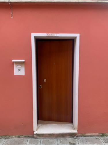 een rood gebouw met een bruine deur erop bij appartamento con cortile in Venetië