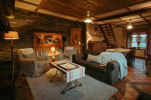 ein Wohnzimmer mit einem Sofa, Stühlen und einem Tisch in der Unterkunft Le Saint Urbain in Nollevaux