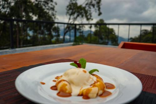 une assiette de nourriture avec de la crème glacée sur une table dans l'établissement Rock n Fall Nature Resort, à Ella