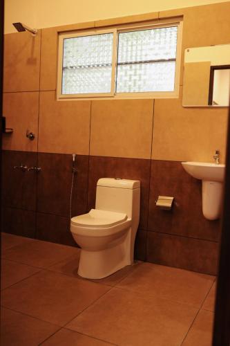 a bathroom with a toilet and a sink at RIVA Marari Beach Homestay in Mararikulam