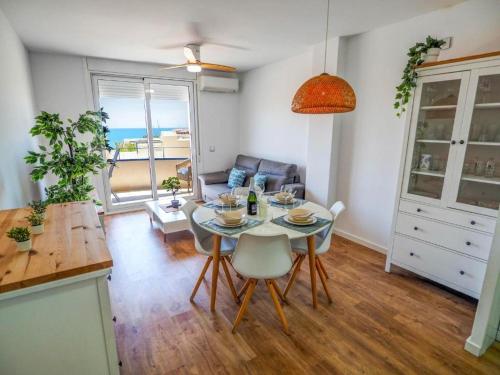 eine Küche und ein Wohnzimmer mit einem Tisch und Stühlen in der Unterkunft Apartment by the Sea by Hello Homes Sitges in Sitges