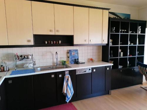 a kitchen with black and white cabinets and a sink at Endless Blue in Pythagoreio