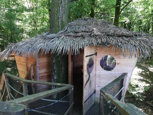 a small hut with a grass roof at Les hébergements insolites de Quénécan in Perret