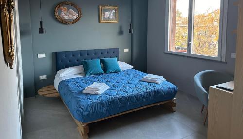 Dormitorio azul con cama con sábanas y almohadas azules en OliVia Home Sauna & Gym en Forlì
