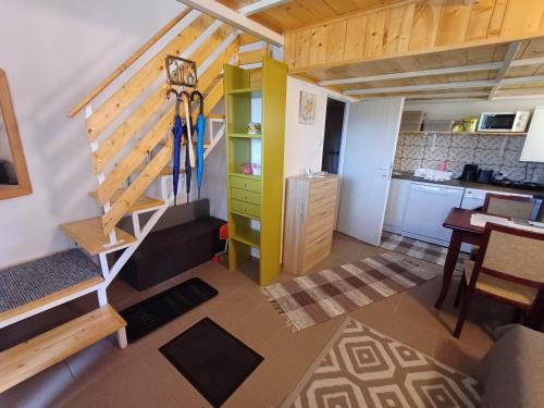 a small room with a staircase and a kitchen at Viola Apartmanok Bogács in Bogács