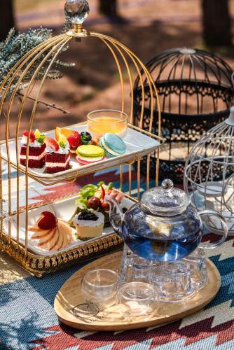 a table with two trays of food and a plate of desserts at Villa PaSon in Khao Kho