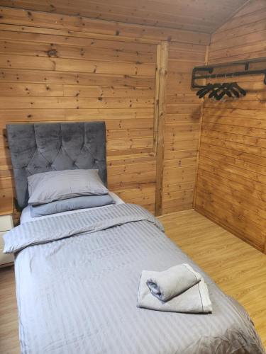 a large bed in a room with wooden walls at Southernwood - Family Lodge in Didcot