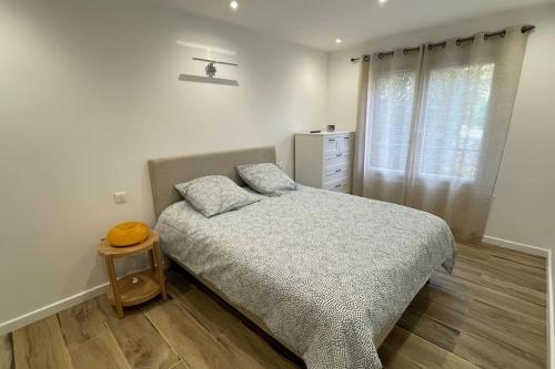 ein Schlafzimmer mit einem Bett und einer Kommode in der Unterkunft Superbe appartement bord de mer in Saint-Mandrier-sur-Mer