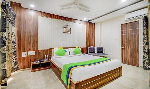 a bedroom with a large bed with green pillows at Hotel Tulsi in Vadodara