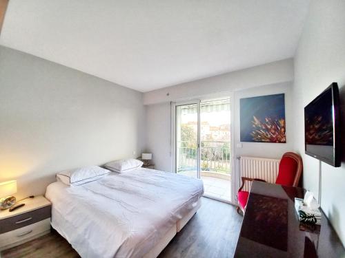 une chambre avec un grand lit et une fenêtre dans l'établissement St Raphaël centre- plages à proximité-tout à pieds, à Saint-Raphaël